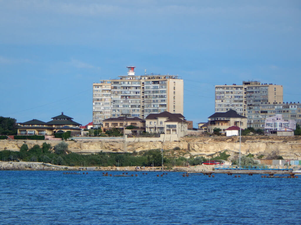 Aktau waterfront with residential buildings, one of which has a lighthouse on top.
