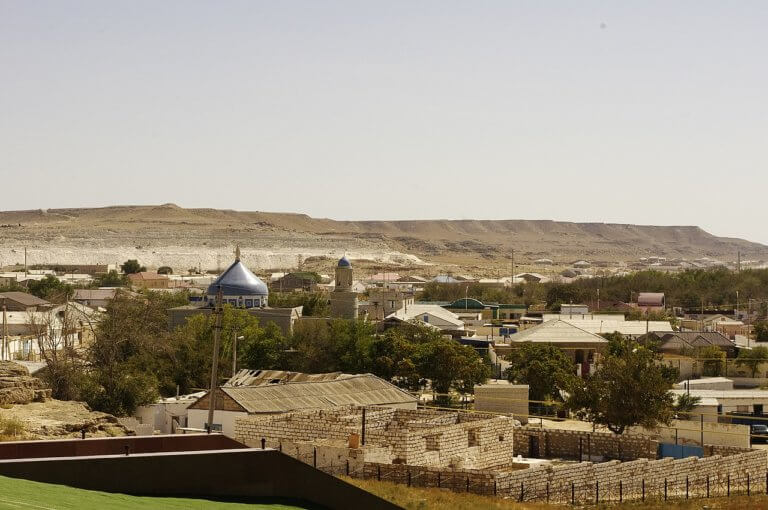 A view of houses in Fort Shevchenko, with desert foothills in the background.