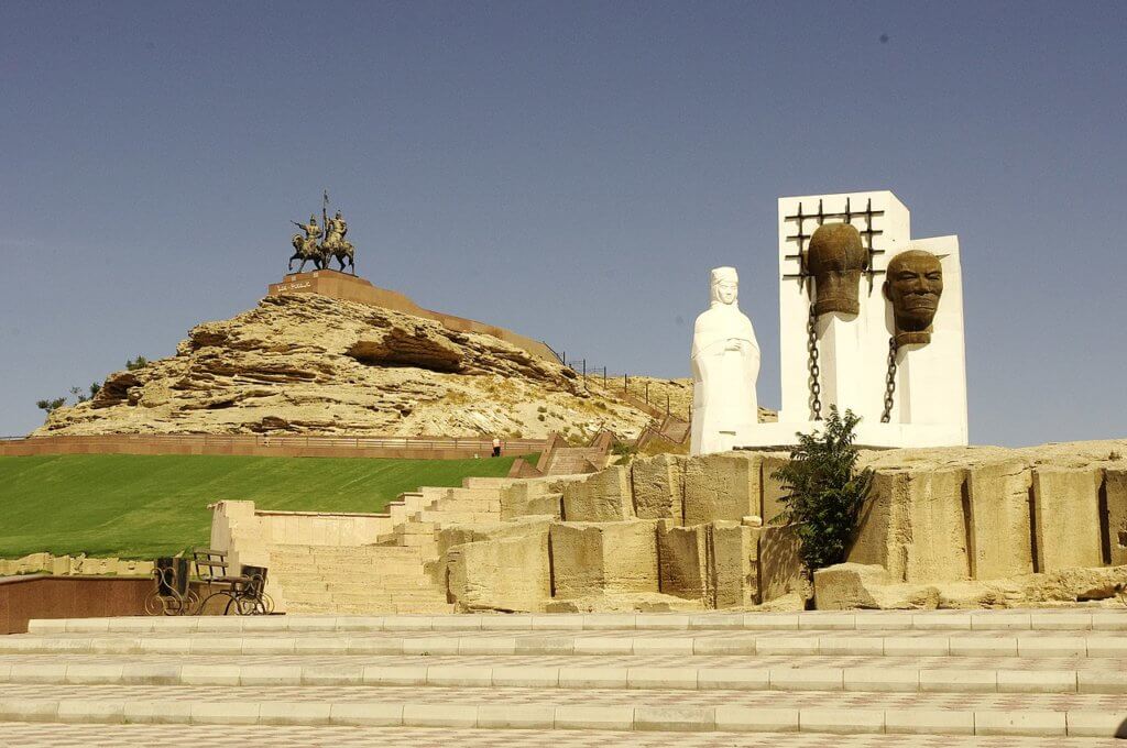 Stalin victim memorial in the foreground and Isa Dosan monument on a hill in the background.