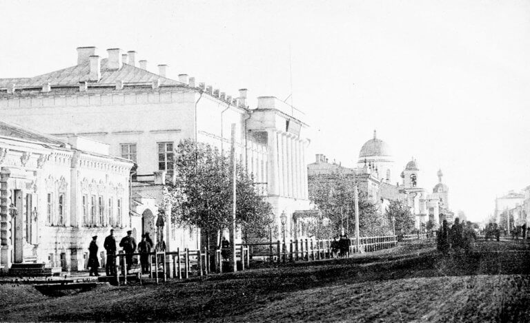 Black and white photo of wide unpaved street and big house in Uralsk 1890s.